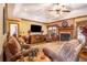 Inviting living room boasts a tray ceiling, brick fireplace, plush seating, and a large screen television at 1824 Colonial South Sw Dr, Conyers, GA 30094