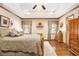 Spacious main bedroom with tray ceiling, fan, wood floors, and natural light at 1824 Colonial South Sw Dr, Conyers, GA 30094