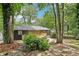 Exterior view of backyard with a wooden deck, garden, and lush green trees providing shade and privacy at 2210 Bolling Brook Sw Dr, Atlanta, GA 30311