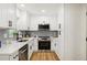 Modern kitchen featuring white cabinets, stainless steel appliances, and tiled backsplash at 2210 Bolling Brook Sw Dr, Atlanta, GA 30311