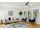 Inviting living room featuring a modern ceiling fan, plush seating, and natural light from the windows at 2210 Bolling Brook Sw Dr, Atlanta, GA 30311