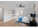 Bright bedroom featuring light wood floors, ceiling fan and a large bed with blue accents at 2385 Tiffany Pl, Decatur, GA 30035