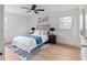 Bright bedroom featuring light wood floors, ceiling fan and a large bed with blue accents at 2385 Tiffany Pl, Decatur, GA 30035