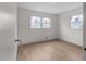 Empty bedroom featuring light wood floors, white walls and two windows at 2385 Tiffany Pl, Decatur, GA 30035