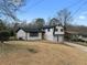 View of home with white brick, black trim, and an attached two-car garage in a fenced yard at 2385 Tiffany Pl, Decatur, GA 30035