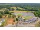 Aerial view of the golf course with a lake, the clubhouse, and surrounding greenery at 274 Westchester Club Dr, Hiram, GA 30141