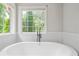 Bright bathroom features a soaking tub, matte black fixtures, and natural light from a large window at 274 Westchester Club Dr, Hiram, GA 30141