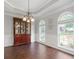 Bright dining room with dark wood floors, arched windows and a beautiful china cabinet under a tray ceiling at 274 Westchester Club Dr, Hiram, GA 30141