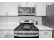 Close-up of a modern stainless steel stovetop, highlighted against white subway tile and white countertops at 274 Westchester Club Dr, Hiram, GA 30141