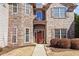 Inviting front entrance with a stone facade and a red door, framed by manicured bushes at 3830 Deer Run Dr, Cumming, GA 30028