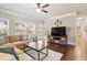 Comfortable living room with a large window overlooking the backyard and a modern ceiling fan at 3830 Deer Run Dr, Cumming, GA 30028