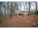 View of backyard with mature trees overlooking deck with outdoor seating area at 1165 Pin Oak Ct, Cumming, GA 30041