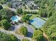 Aerial view of the community pool and tennis courts surrounded by lush trees at 1165 Pin Oak Ct, Cumming, GA 30041