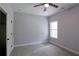 Sunlit bedroom with a window, neutral carpet and walls, and closet access through a white door at 2117 Hwy 101 N, Dallas, GA 30157