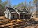 Attractive new home featuring a covered front porch with stone accents and light siding in a wooded setting at 2117 Hwy 101 N, Dallas, GA 30157