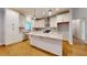 Bright kitchen boasts white cabinets, granite countertops, stainless steel appliances, and wood flooring at 2117 Hwy 101 N, Dallas, GA 30157