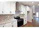 Modern kitchen features white cabinets, stainless steel appliances, granite countertops, and eye-catching backsplash at 2117 Hwy 101 N, Dallas, GA 30157