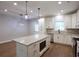 Open kitchen showcases white cabinets, a granite island, modern lighting, and stainless steel appliances at 2117 Hwy 101 N, Dallas, GA 30157