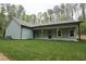Rear elevation featuring a covered porch with wooden support beams overlooking the lawn at 2117 Hwy 101 N, Dallas, GA 30157