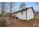 Back of white-painted brick home features a new roof, a wooden deck, and mature trees at 365 Cowan Rd, Covington, GA 30016