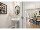 Modern powder room with a pedestal sink, round mirror, and stylish decor at 125 Maplewood Ln, Conyers, GA 30094