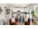 Modern white kitchen with stainless steel appliances, dining table, and natural light from a nearby window at 125 Maplewood Ln, Conyers, GA 30094