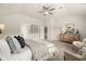 Spacious main bedroom featuring vaulted ceilings, ceiling fan, modern dresser and comfortable sitting area at 125 Maplewood Ln, Conyers, GA 30094