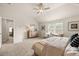 Well-lit main bedroom showcasing a ceiling fan, a patterned wood dresser, and comfortable sitting chairs at 125 Maplewood Ln, Conyers, GA 30094