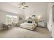 Spacious main bedroom with a tray ceiling, plush carpet, and a large window for natural light at 125 Maplewood Ln, Conyers, GA 30094