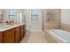 Bathroom featuring double sink vanity, soaking tub, and tiled shower at 2300 Peachford Rd # 3411, Atlanta, GA 30338