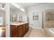 Bathroom featuring double sink vanity, soaking tub, and tiled shower at 2300 Peachford Rd # 3411, Atlanta, GA 30338