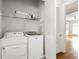 Convenient laundry room includes washer, dryer, and shelving for storage at 2300 Peachford Rd # 3411, Atlanta, GA 30338