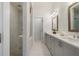 Modern bathroom with a glass-enclosed shower, double vanity with gray cabinetry, and tiled floors at 2320 Edgar Park Pl # 95, Duluth, GA 30096