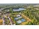 Aerial view of the community with lake, clubhouse, swimming pool, and tennis courts among mature trees at 283 Harmony Lake Dr, Canton, GA 30115