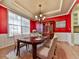 Elegant dining room featuring a large window, hardwood floors, chandelier, and bold red accent wall at 283 Harmony Lake Dr, Canton, GA 30115