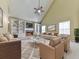 Bright living room features a cozy fireplace, vaulted ceiling, built-in bookshelves, and a ceiling fan at 283 Harmony Lake Dr, Canton, GA 30115