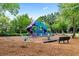 Community playground featuring swings, slides, and other play equipment surrounded by mature trees at 283 Harmony Lake Dr, Canton, GA 30115