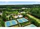 Aerial view of community tennis courts and pool surrounded by mature trees and a lake in the background at 283 Harmony Lake Dr, Canton, GA 30115