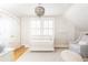 Bedroom with a white crib, light gray walls, hardwood floors, and a beaded chandelier at 2911 N Hills Ne Dr, Atlanta, GA 30305