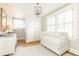 Bedroom with a white crib, light gray walls, hardwood floors, and a beaded chandelier at 2911 N Hills Ne Dr, Atlanta, GA 30305