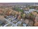 Aerial view showing houses amid a forest setting with colorful autumn trees and a distant lake at 3109 Meadow Wood Ct, Lawrenceville, GA 30044