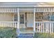 Inviting porch featuring stone details, a bright white door, and decorative holiday lighting at 3109 Meadow Wood Ct, Lawrenceville, GA 30044