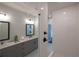 Modern bathroom with gray vanity, double sinks, and a glass-enclosed shower featuring white subway tile at 604 Goldsmith Ct # 115, Johns Creek, GA 30022