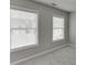 Sunlit bedroom featuring neutral walls, carpet, and two windows at 2341 Walnut Tree Ct, Buford, GA 30519