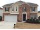Charming two-story home featuring a brick facade, attached two-car garage, and well-manicured front yard at 2098 Cutleaf Creek Rd, Grayson, GA 30017
