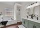 Bathroom showcasing double vanity with modern mirrors, tub-shower combination, and a serene view at 2121 Lindley Nw Ln, Kennesaw, GA 30144