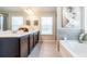 Bathroom featuring double vanity, soaking tub, and tiled floor at 123 Maplewood Ln, Conyers, GA 30094