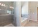 Bathroom featuring glass-enclosed shower and soaking tub at 123 Maplewood Ln, Conyers, GA 30094