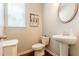 Bathroom features a pedestal sink, a toilet, and a small cabinet with light walls at 123 Maplewood Ln, Conyers, GA 30094