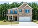 Charming two-story brick home featuring a two-car garage and well-manicured lawn at 123 Maplewood Ln, Conyers, GA 30094